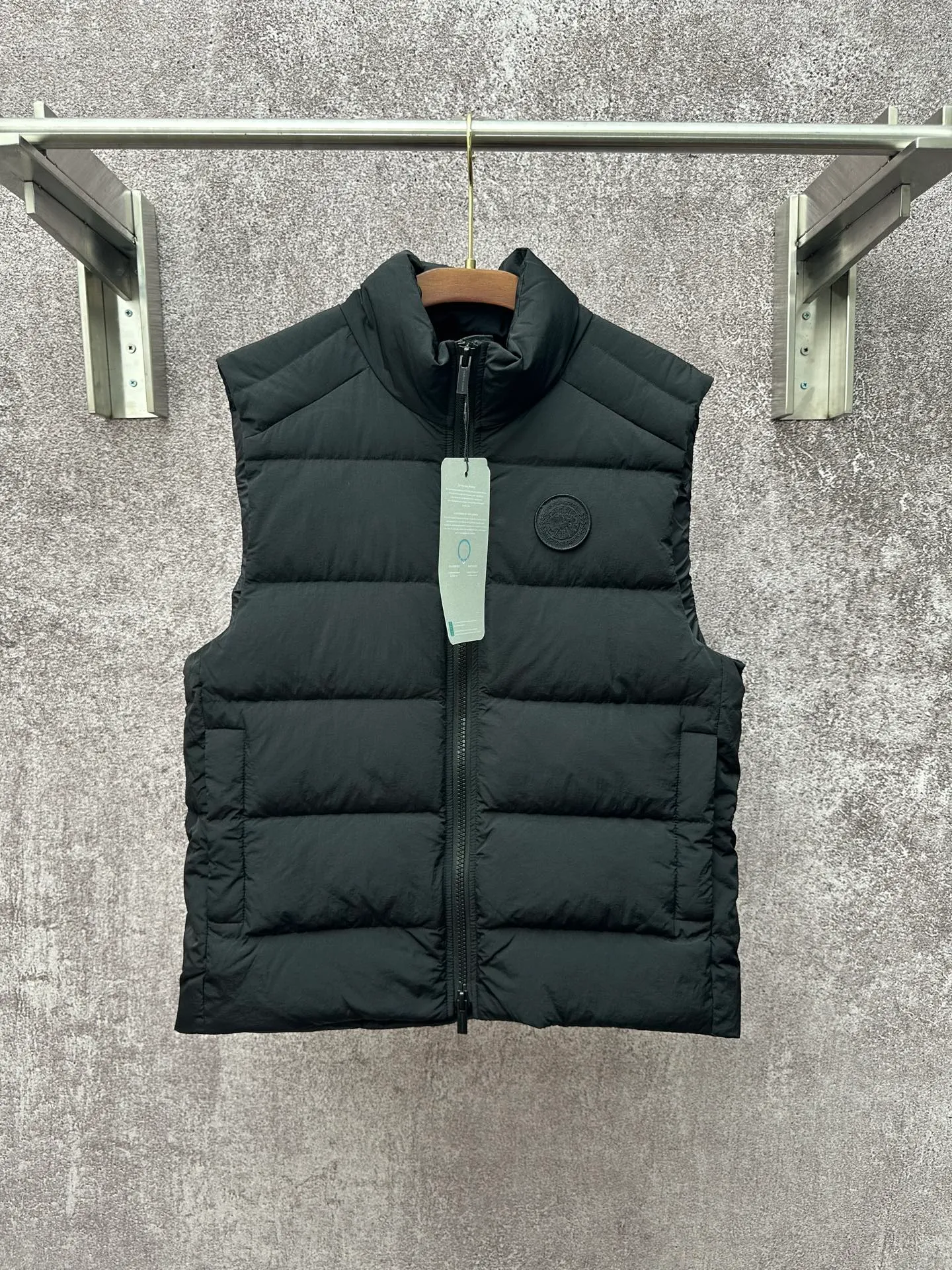 P720 Canada Goose Badge Down Vest Fabric selection: The use of high-quality protective nylon fabric not only enhances the wear resistance of the surface, but also takes into account wind resistance, ensuring excellent performance in various harsh weather conditions.  90 national standard high-quality white duck down: selected high-loft down, weighing 160g, light and warm, with excellent temperature locking performance and good resilience.  Three-dimensional quilting process: Precision thread reinforcement to prevent velvet drilling and ensure that the fluffy and resilient elasticity lasts as new.  Details: The ribbon is woven with polyester as the base, and the brand letters are decorated on the ribbon through high-precision computer embroidery. The edges of the pattern are clear, the stitches are fine and even, and multiple layers of embroidery thread are stacked to enhance the three-dimensional effect. Accessories: One-to-one customized logo, one-to-one customized zipper puller, one-to-one customized three-label SIZE: S M L XL